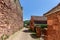 Ordinary medieval settlement outside perimeter of second protective red-stone walls andÂ  cobblestone pavement leading to valley